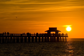 Sunset In Naples Florida. With Pier-Cottage- In The Foreground